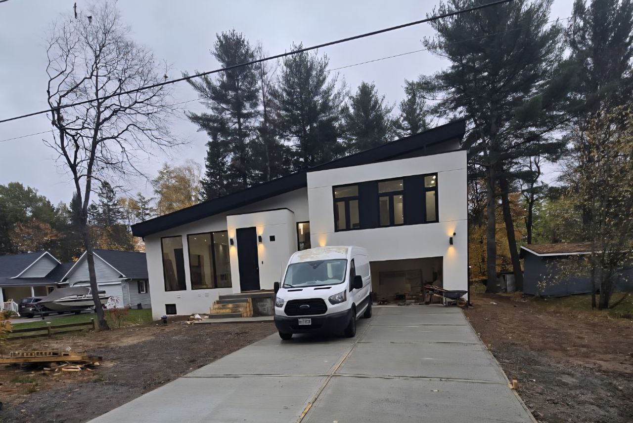 Modern two-storey custom home with stucco finish and large triple-glazed aluminum windows in Sundridge, Muskoka